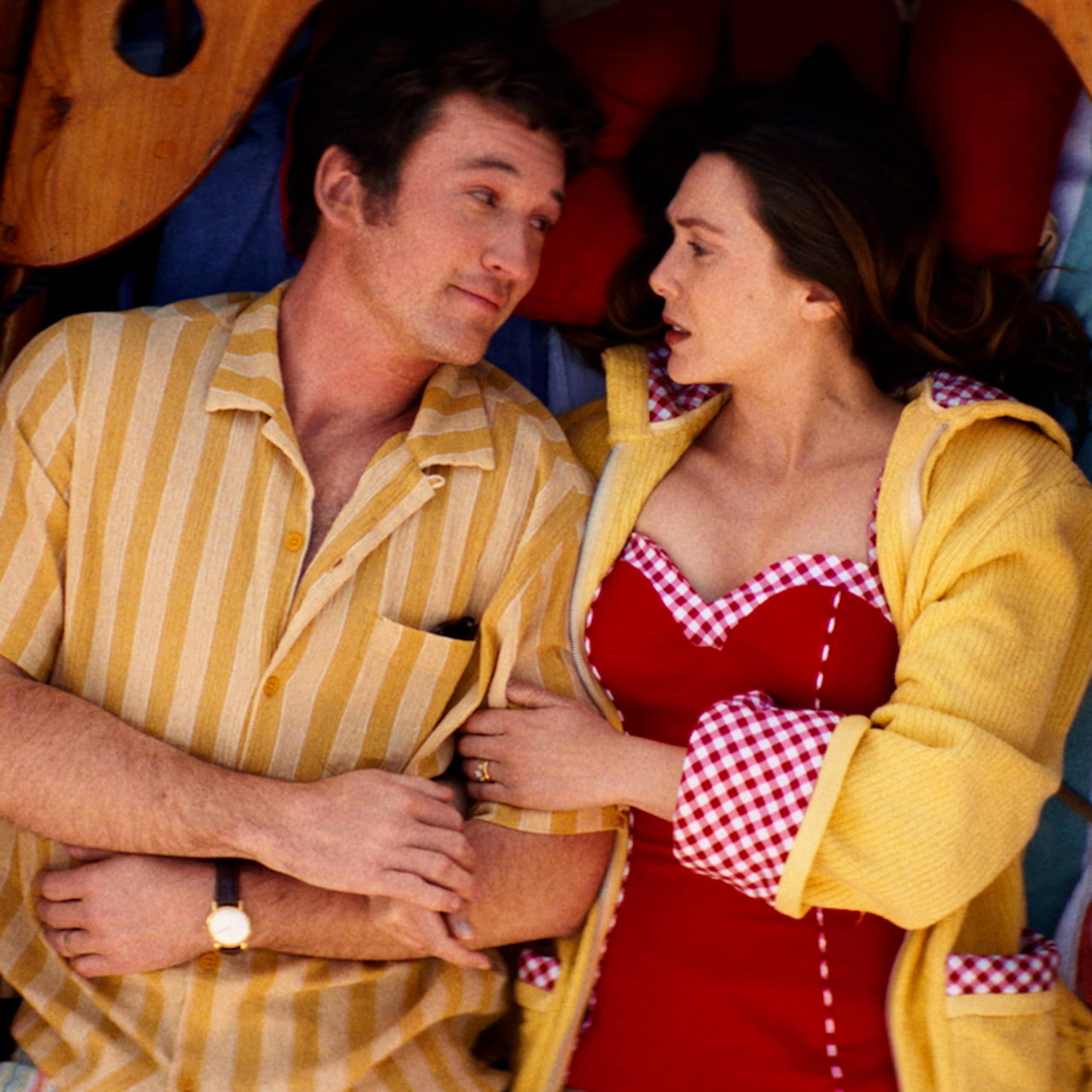 Miles Teller and Elizabeth Olsen lying down in a boat.