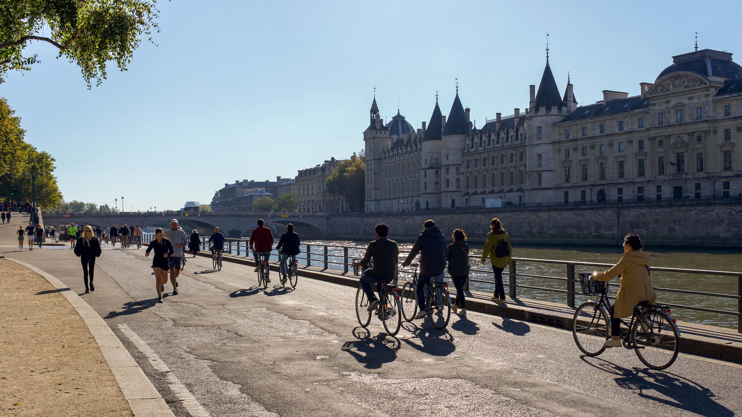 Photo de piétons et cyclistes prise à Paris, sur les voies sur berge, en face de la Conciergerie