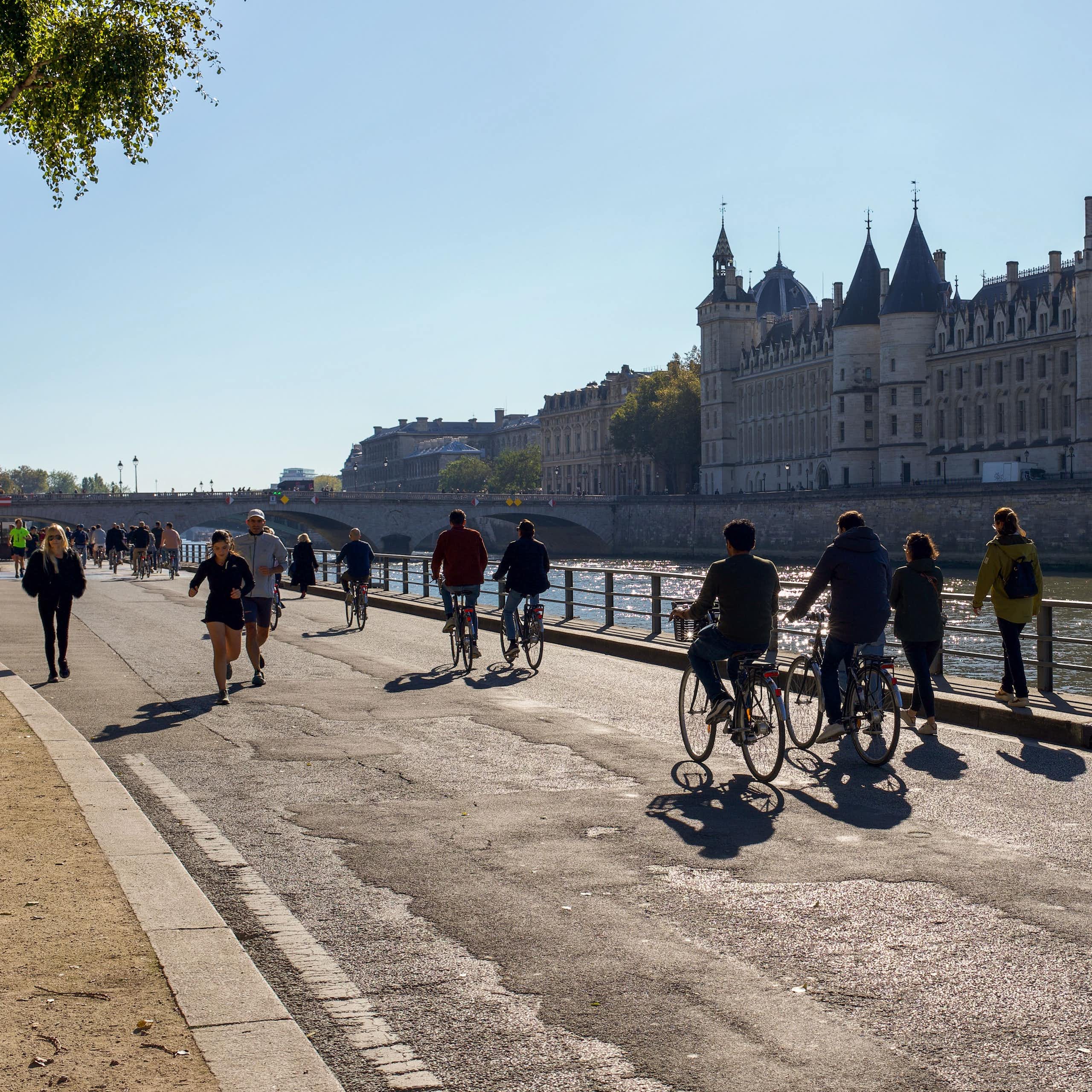 Photo de piétons et cyclistes prise à Paris, sur les voies sur berge, en face de la Conciergerie