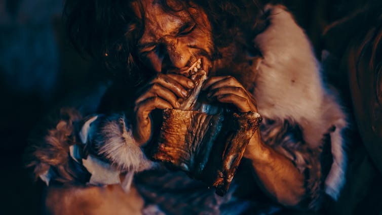 A caveman chewing on a bone.