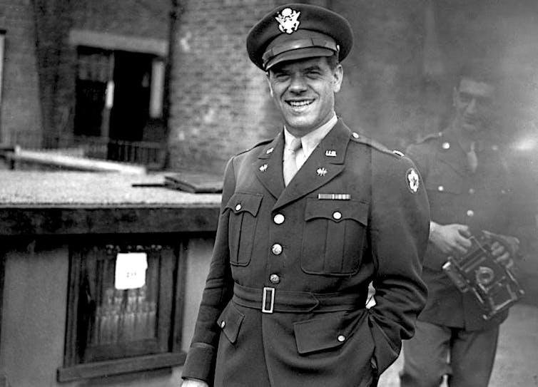 Young man posing and smiling while wearing a military uniform.