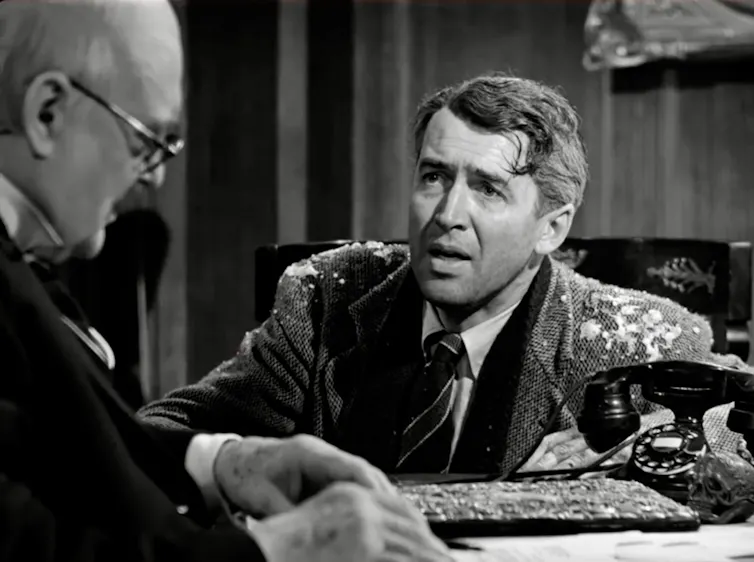 Black-and-white movie still of a distraught man with snow on his jacket.