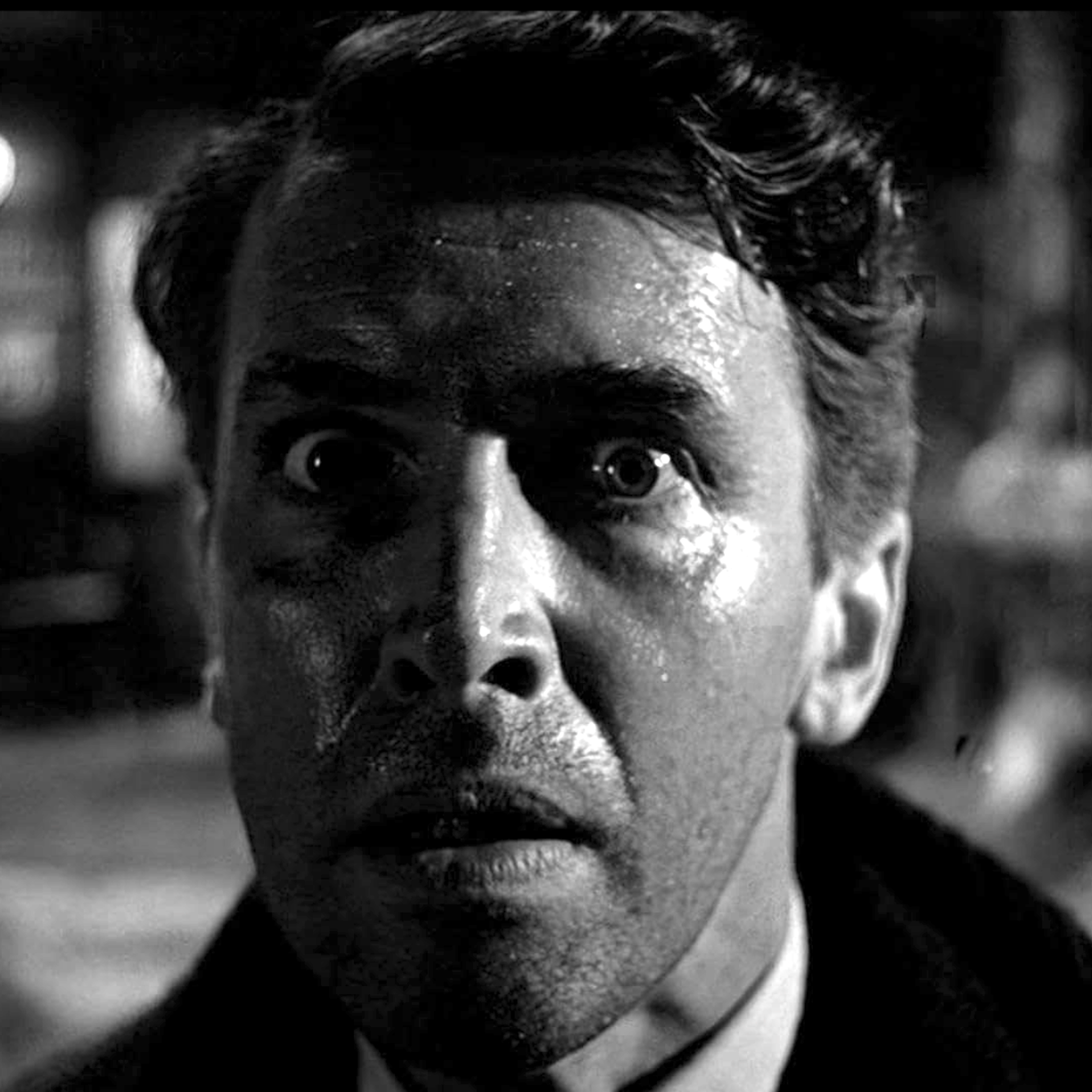 Black-and-white close-up of the face of a distraught young man.