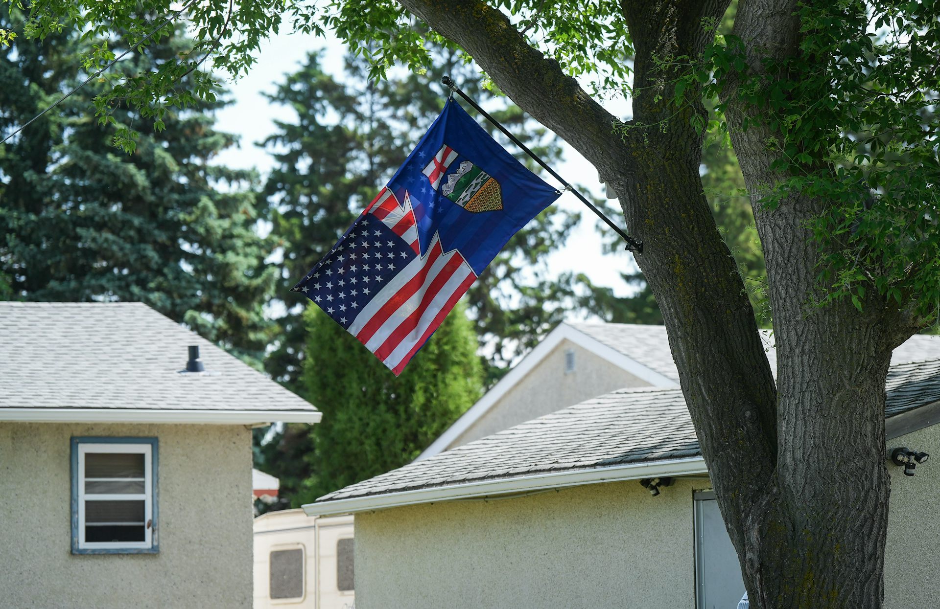 A mashup of an Alberta-U.S. flag hangs in someone's backyard.