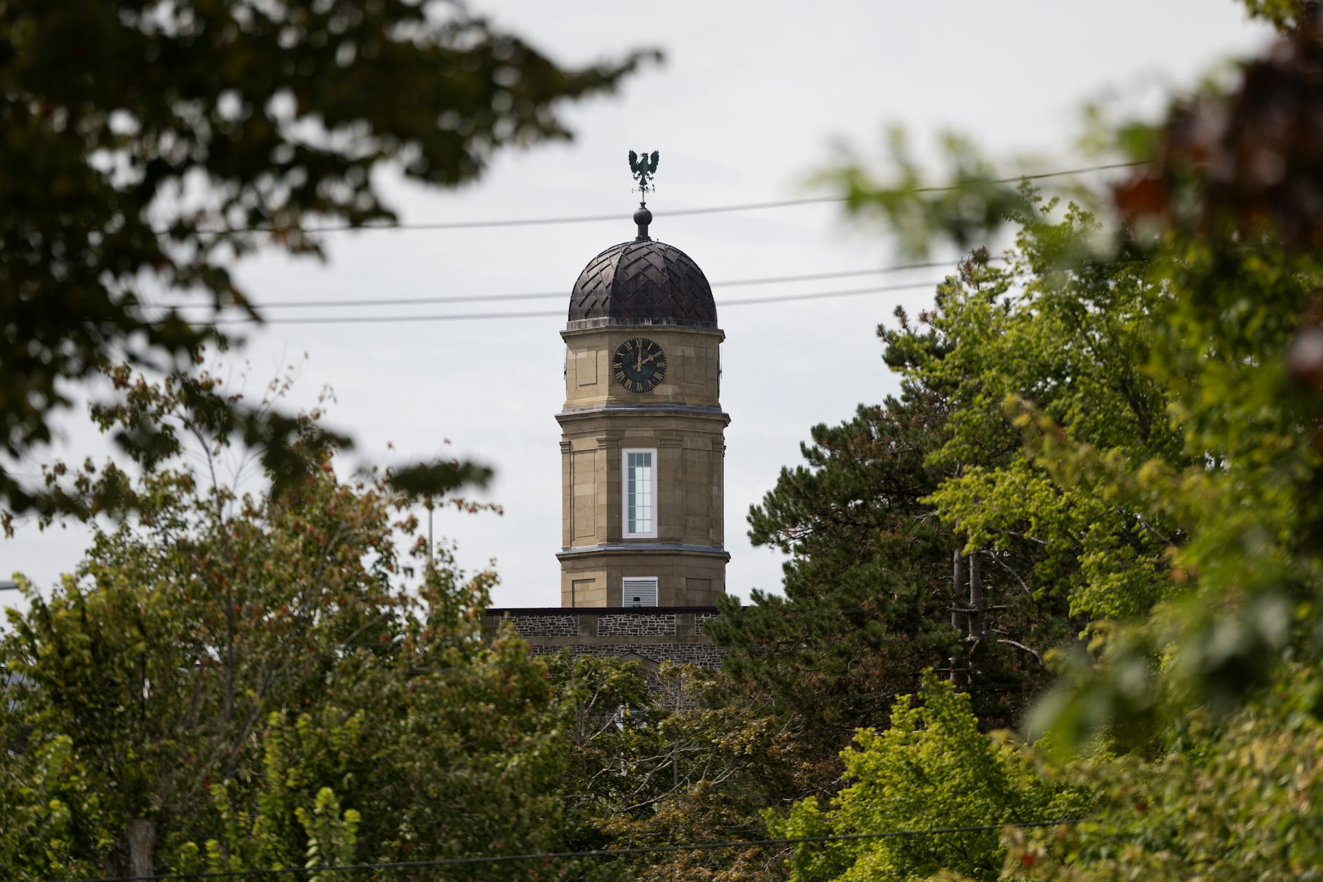 A clock tower seen atop a stone building.