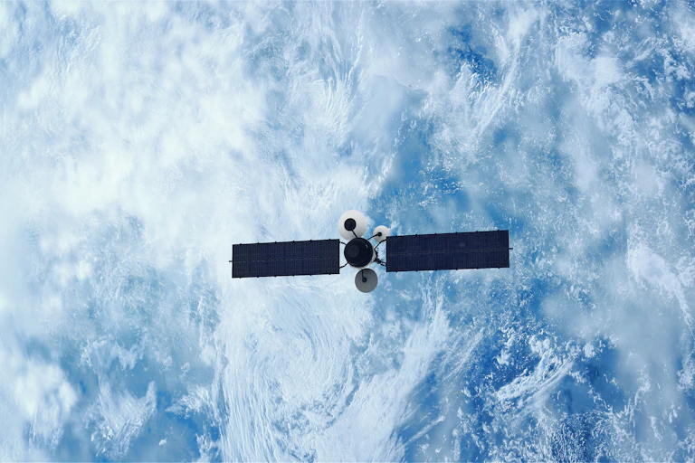 An illustration of a satellite shown above the cloudy surface of Earth