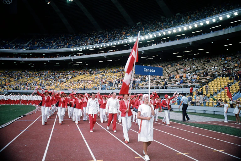 Une athlète porte le drapeau canadien