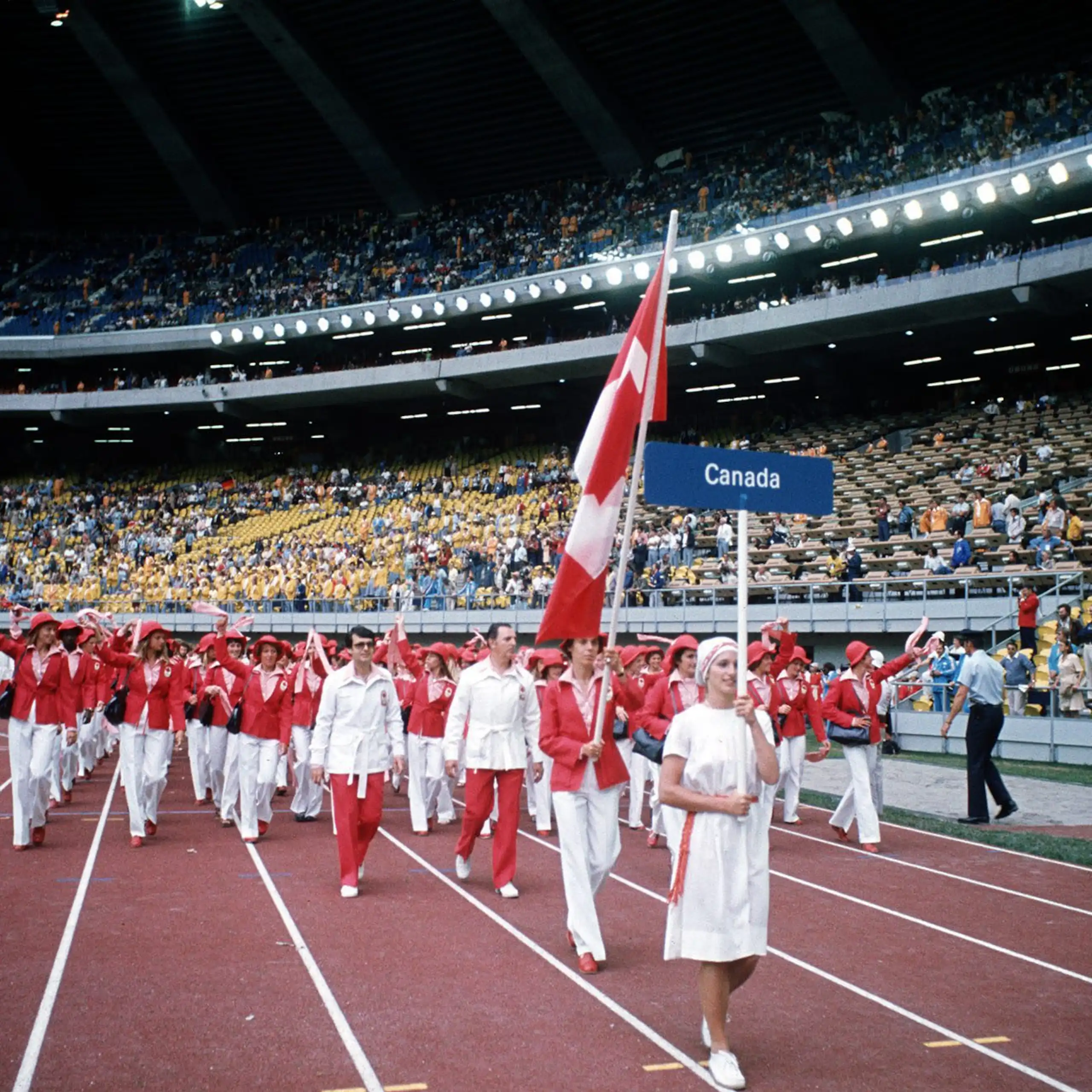 Une athlète porte le drapeau canadien