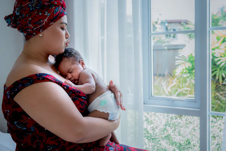 Baby sleeping against woman's chest