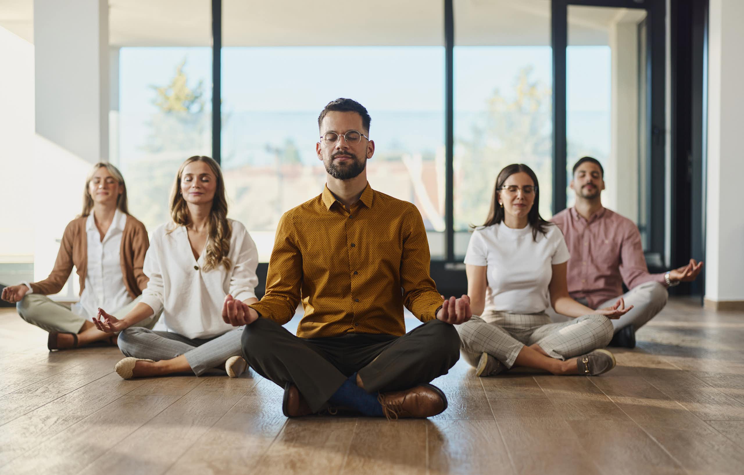 Lima orang bermeditasi dengan mata terpejam sambil duduk dalam posisi teratai