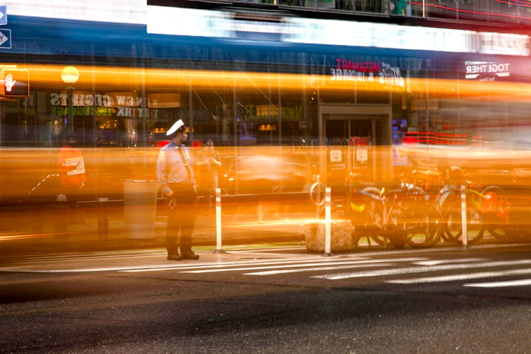 A timelapse of a busy city street with amber lights streaking across the scene.