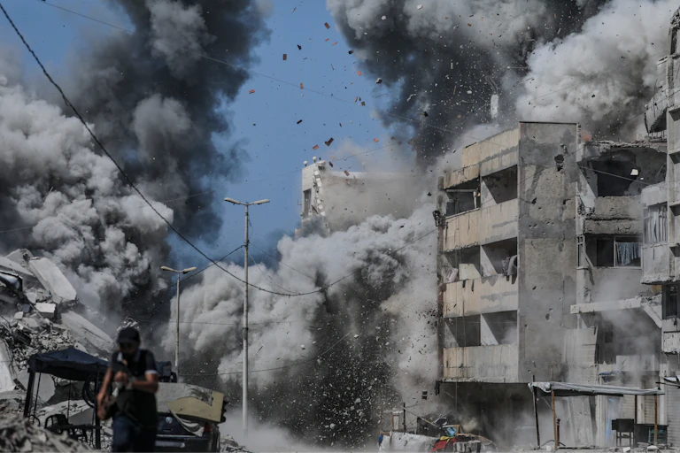 A Palestinian man takes cover following an Israeli air strike during a military operation in Gaza City, Gaza Strip, 27 September 2025