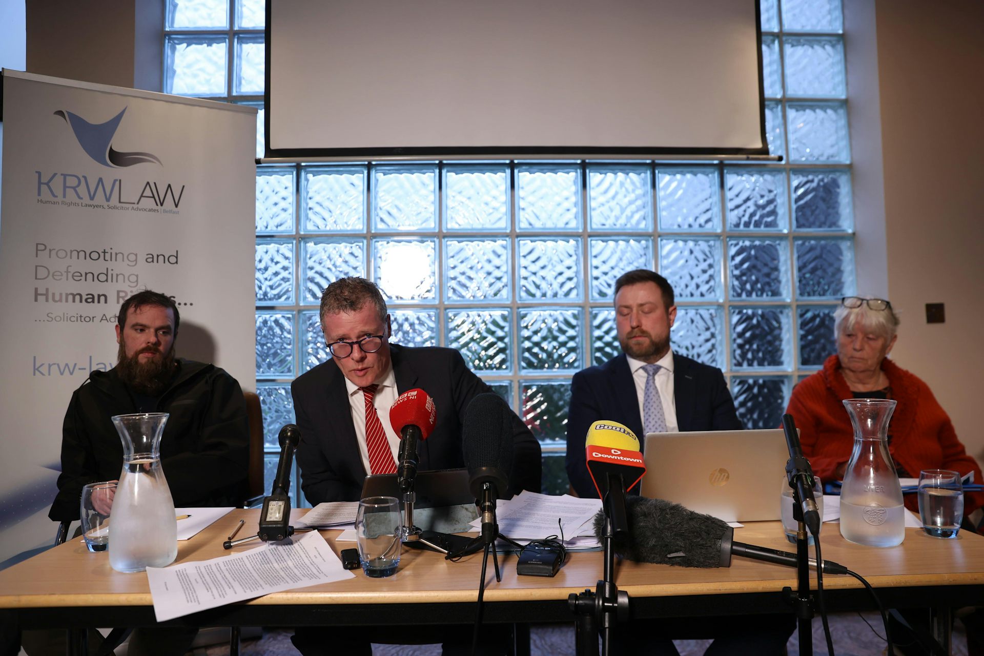 A lawyer and three family members giving a press conference.