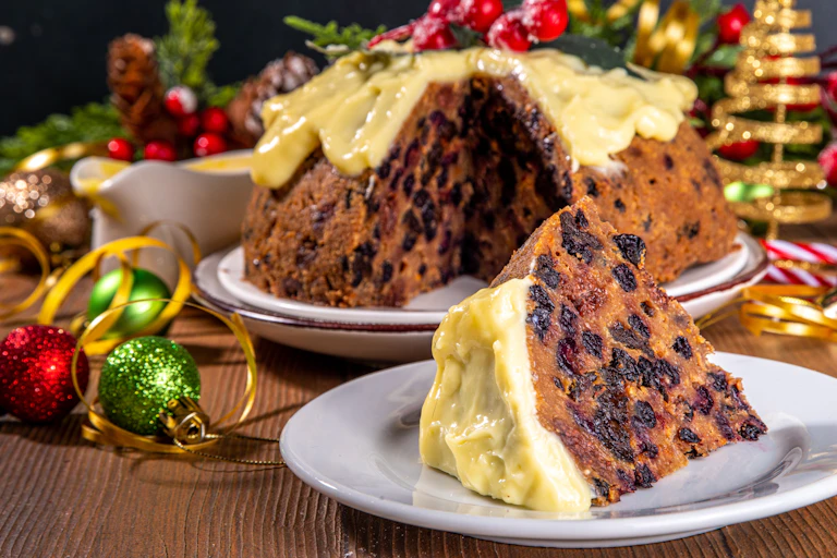 Christmas cake surrounded by Christmas decorations.