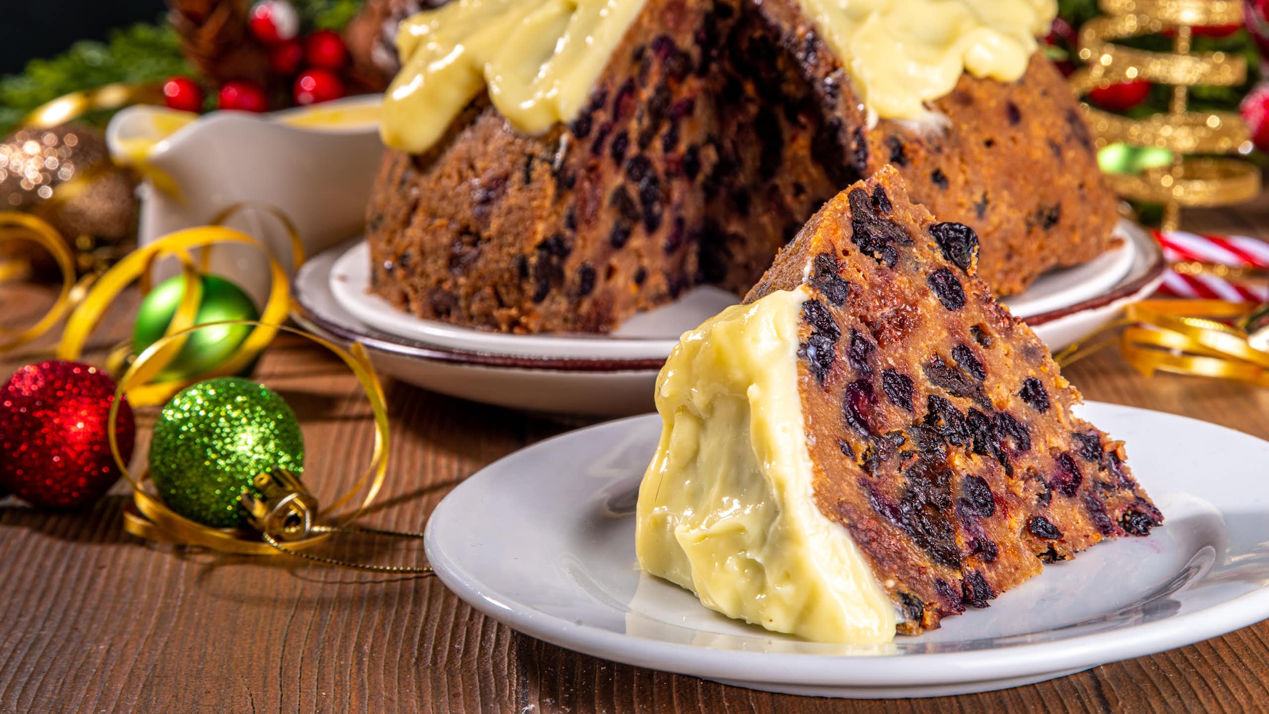 Christmas cake surrounded by Christmas decorations.