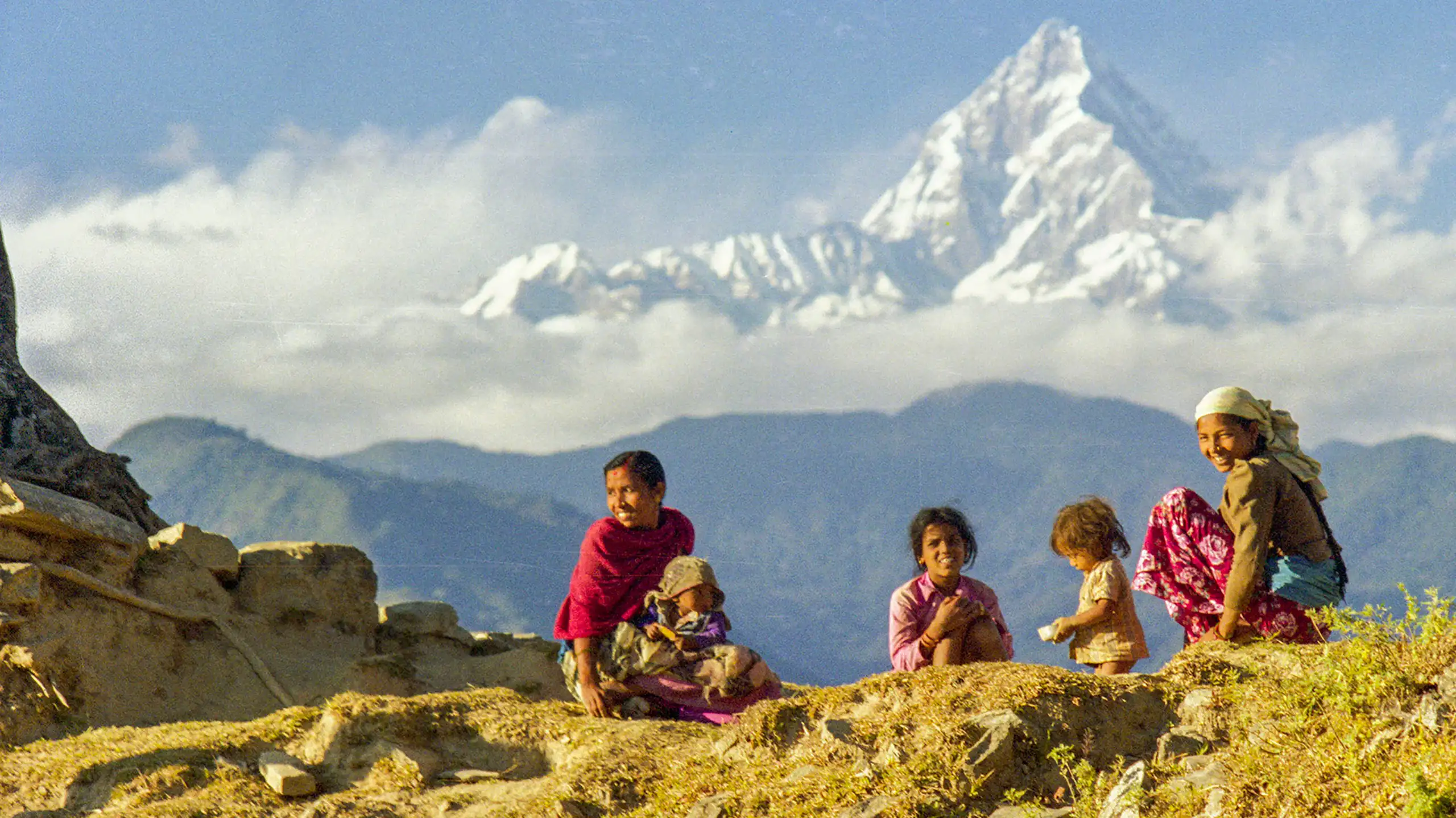Empat anak perempuan Nepal berdiri di punggung pegunungan.