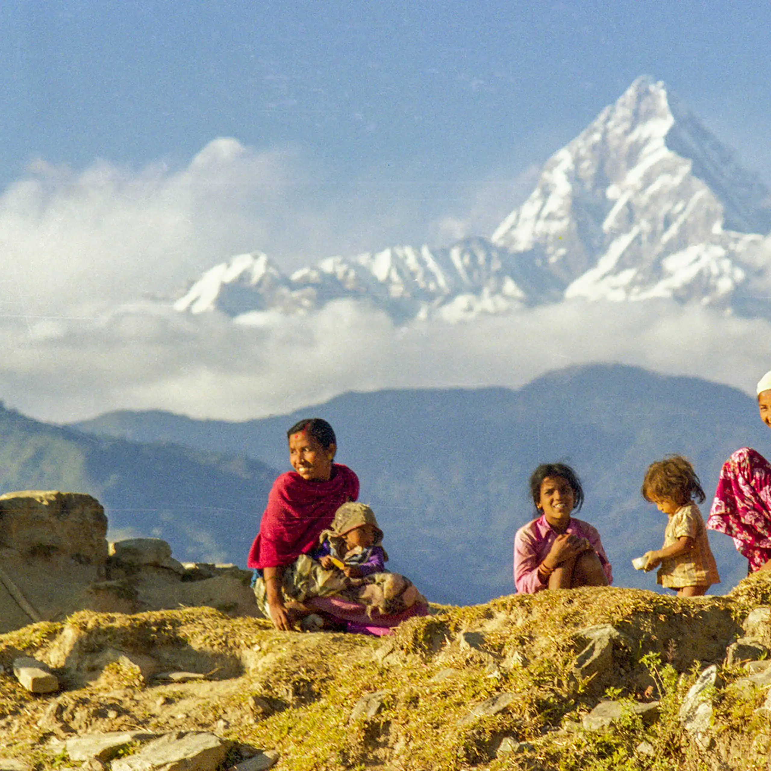 Empat anak perempuan Nepal berdiri di punggung pegunungan.