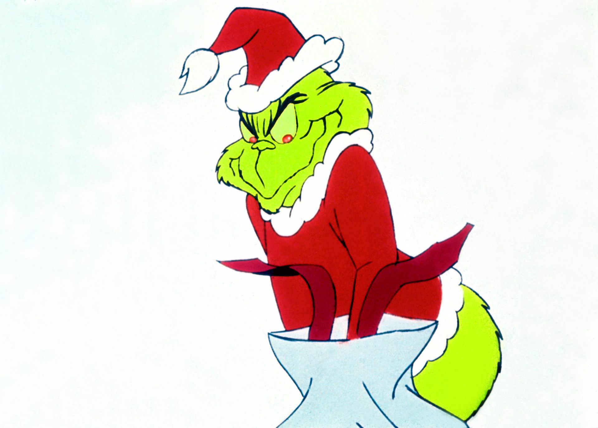 A movie still of the Grinch from the 1966 cartoon adaptation, where he's stuffing stolen presents into a bag.