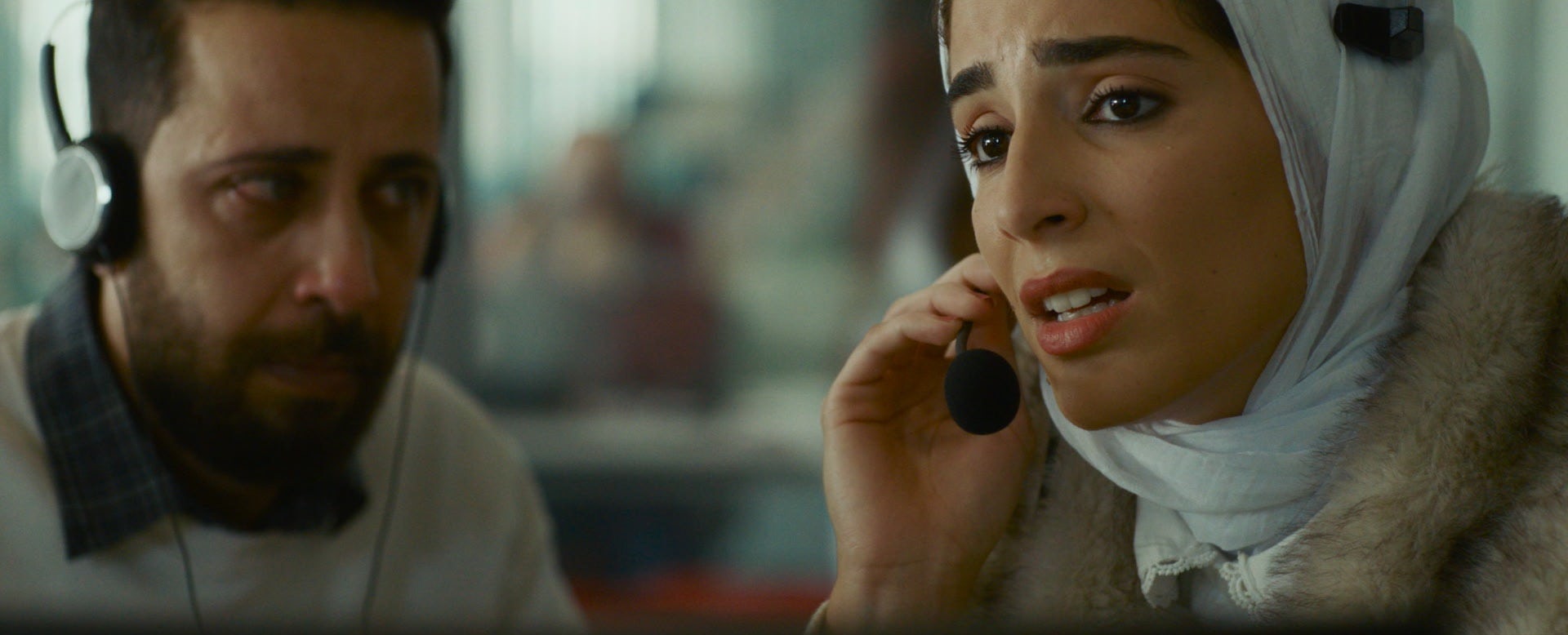 Dos voluntarios hablan con la niña a través de auriculares y micrófonos.