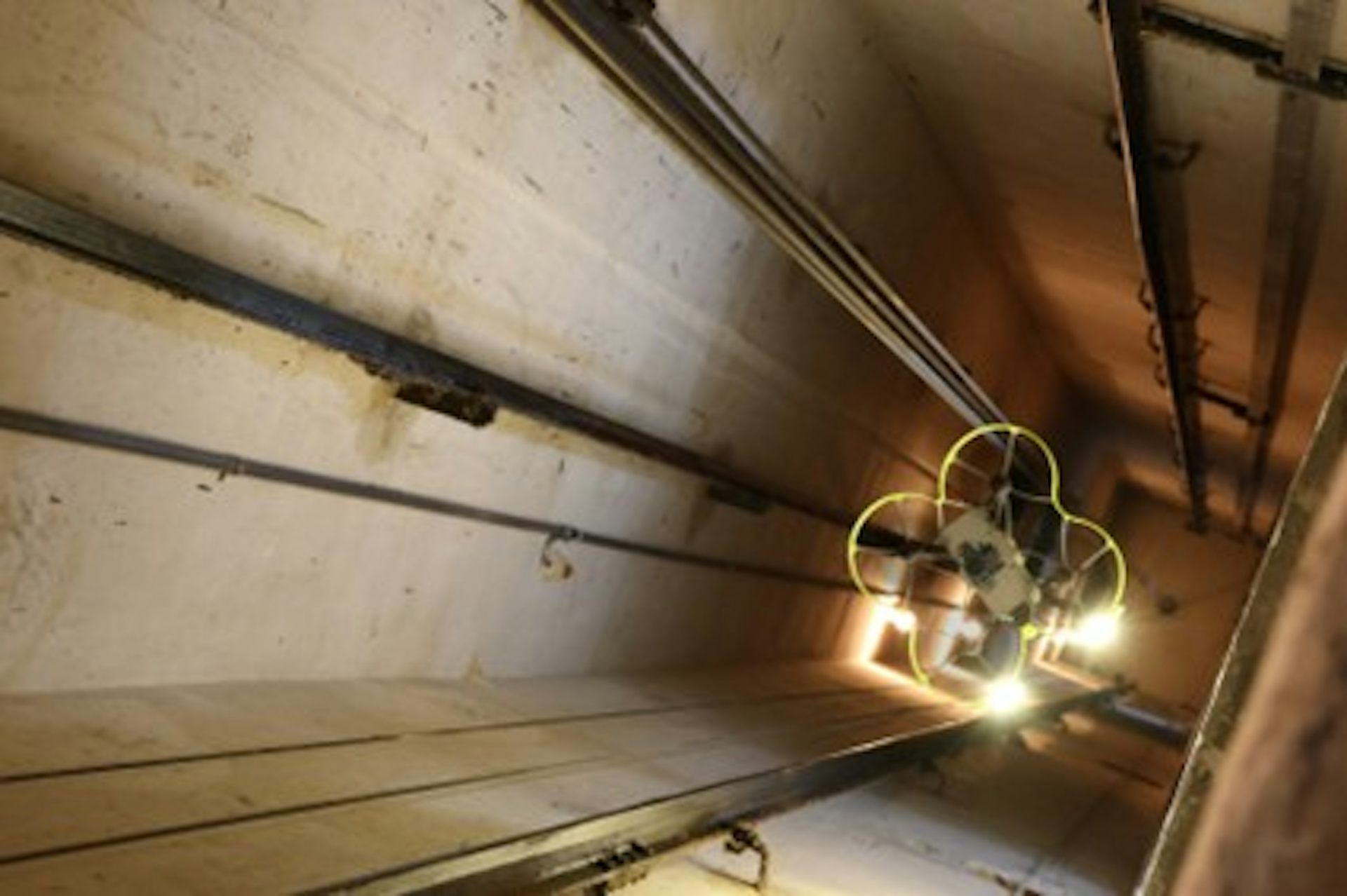 El dron Hovering Solutions vuela entre los cables del hueco del ascensor mientras realiza su inspección.