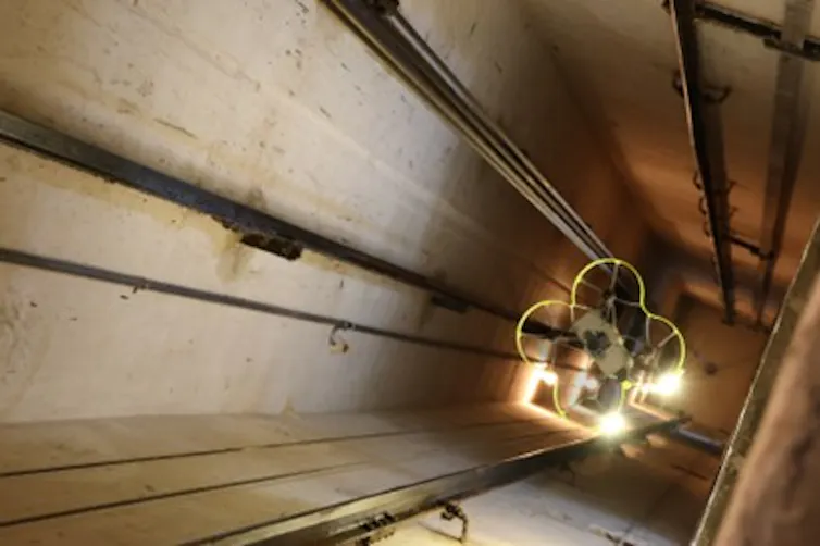 El UAV de Hovering Solutions vuela entre los cables del hueco del ascensor mientras realiza su inspección.
