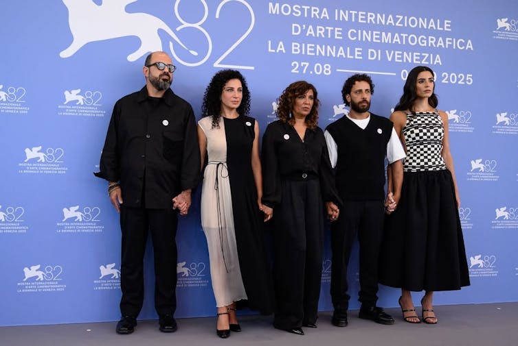 Un grupo de personas serias delante de un photocall.