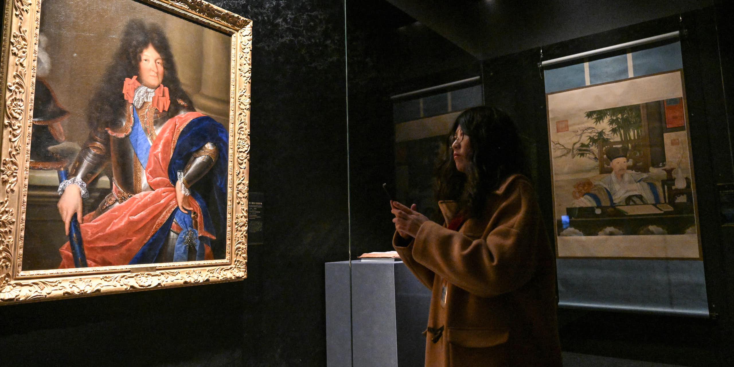 Une femme admirant le portrait de Louis XIV