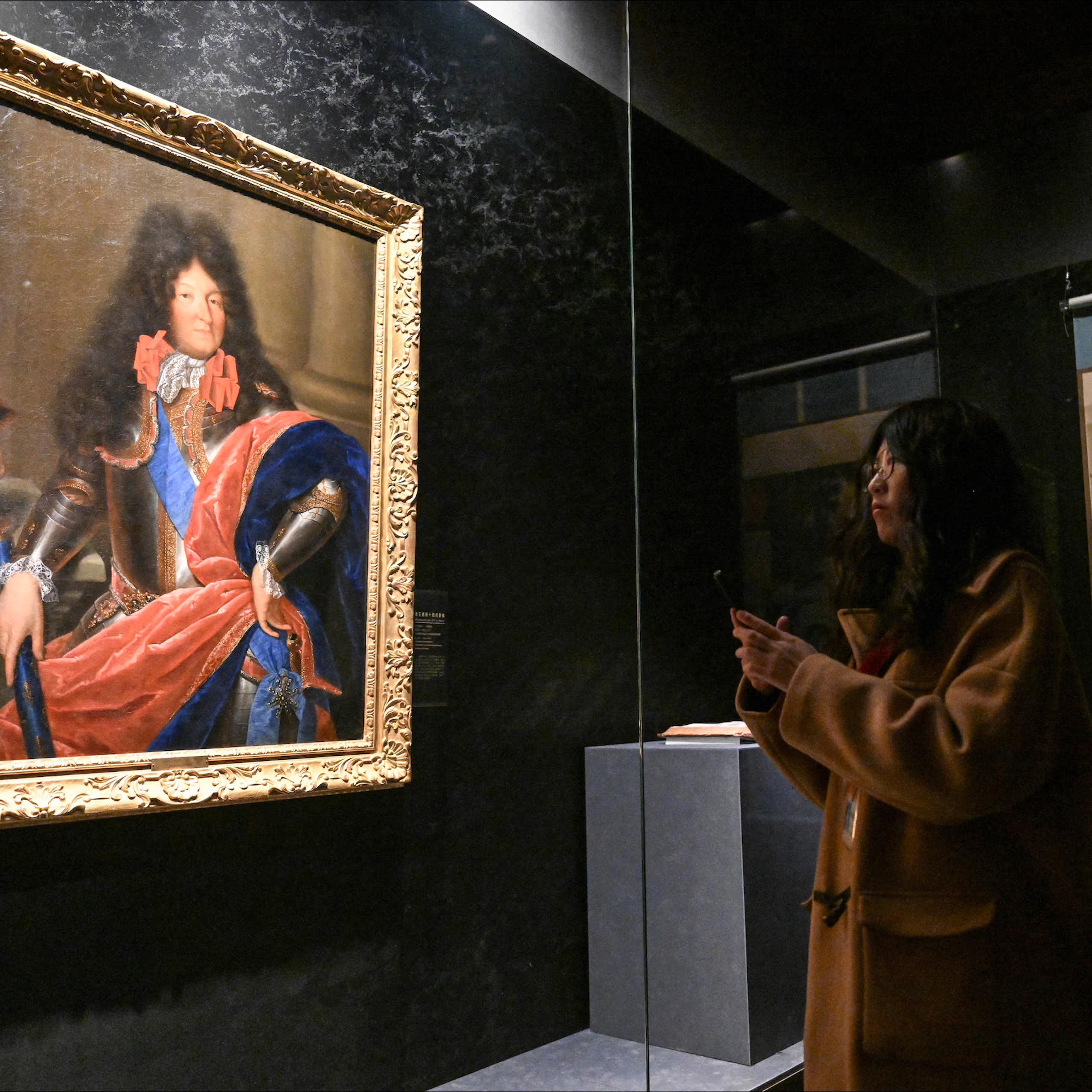 Une femme admirant le portrait de Louis XIV