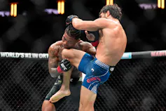 Un athlète de sport de combat assène un coup de genou à son adversaire