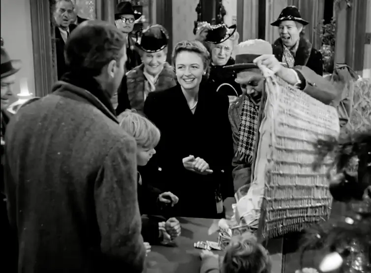 A group of smiling people dump a large basket of cash on a desk.
