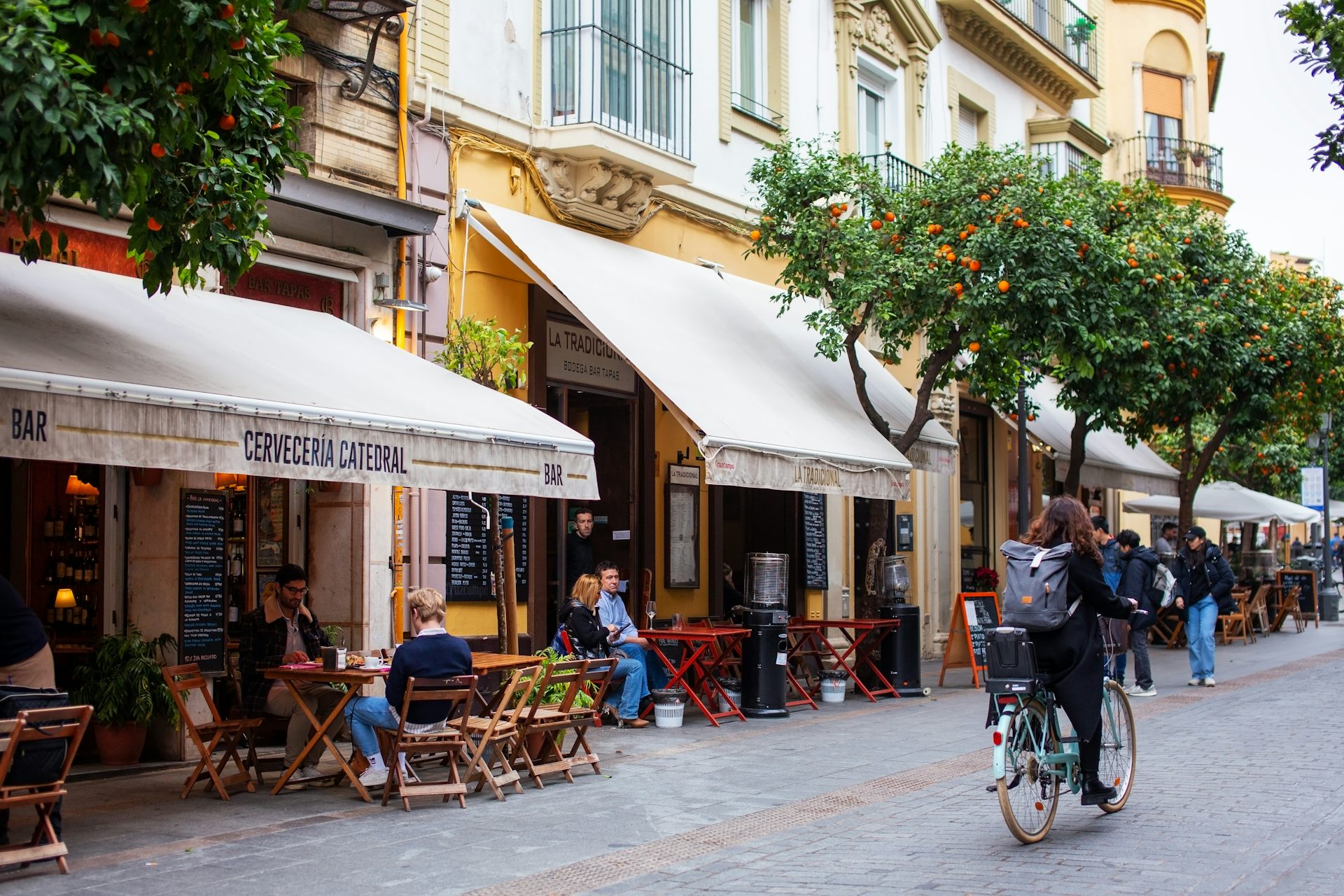 Una calle de Sevilla donde se pueden leer los nombres de varios establecimientos.