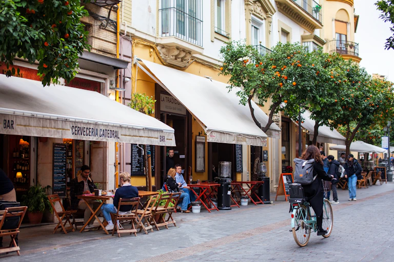 Una calle de Sevilla donde se pueden leer los nombres de varios establecimientos.