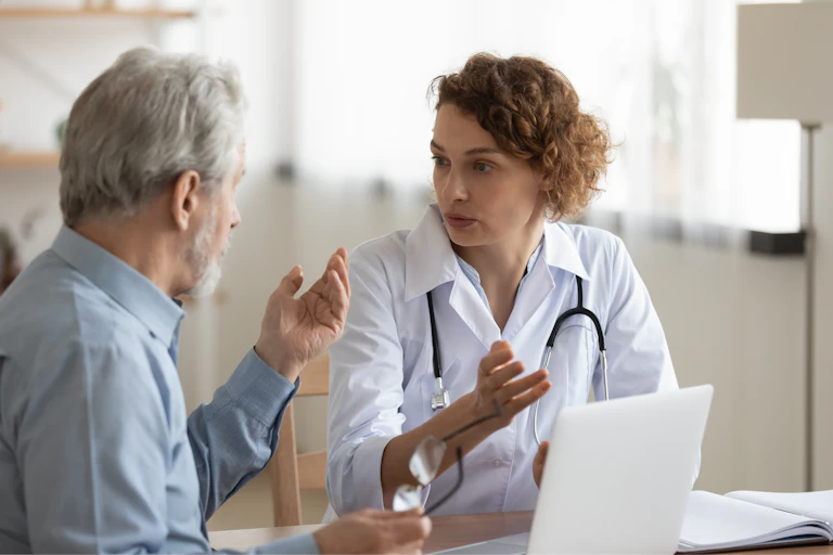 Una médica hablando con un paciente.