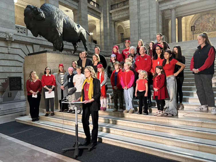 People standing on steps and one person is at a microphone.