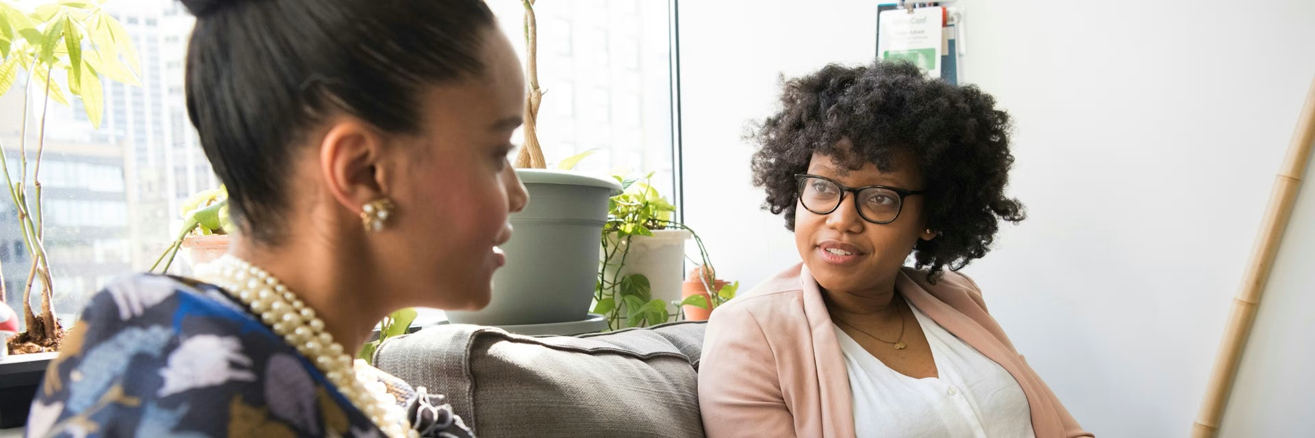 Deux femmes assises côte à côte, en train de discuter