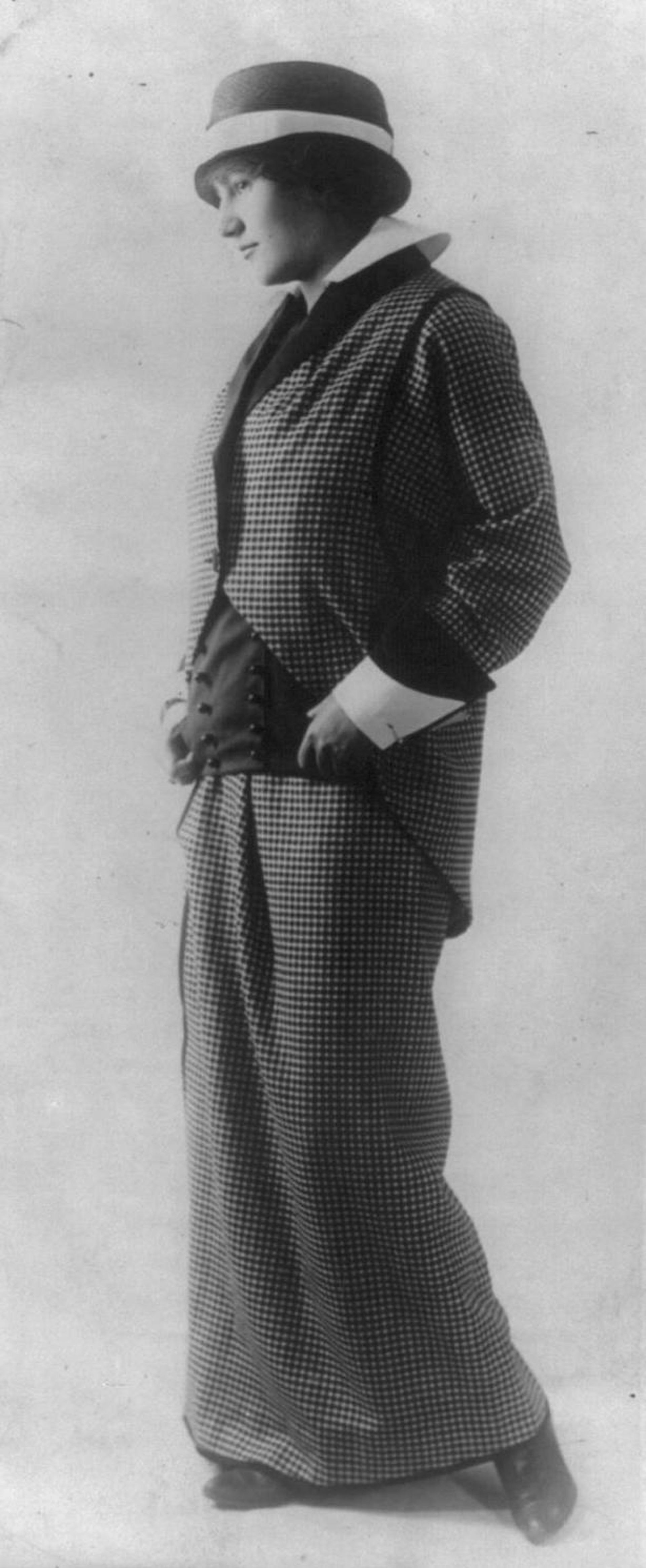 Black and white photo of a woman wearing a plaid pantsuit.