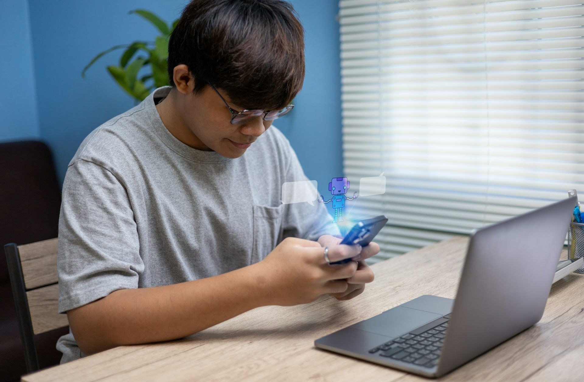 Adolescent assis à la maison utilisant son smartphone pour converser avec un chatbot.