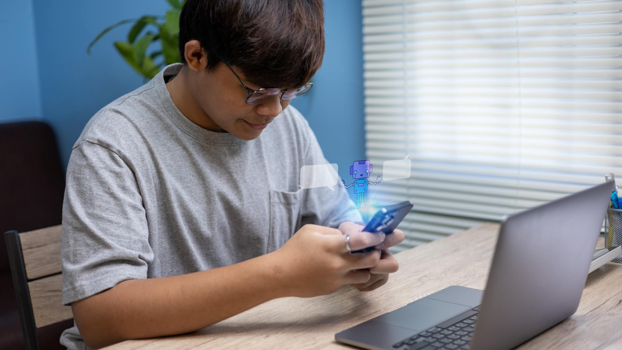 Adolescent assis à la maison utilisant son smartphone pour converser avec un chatbot.