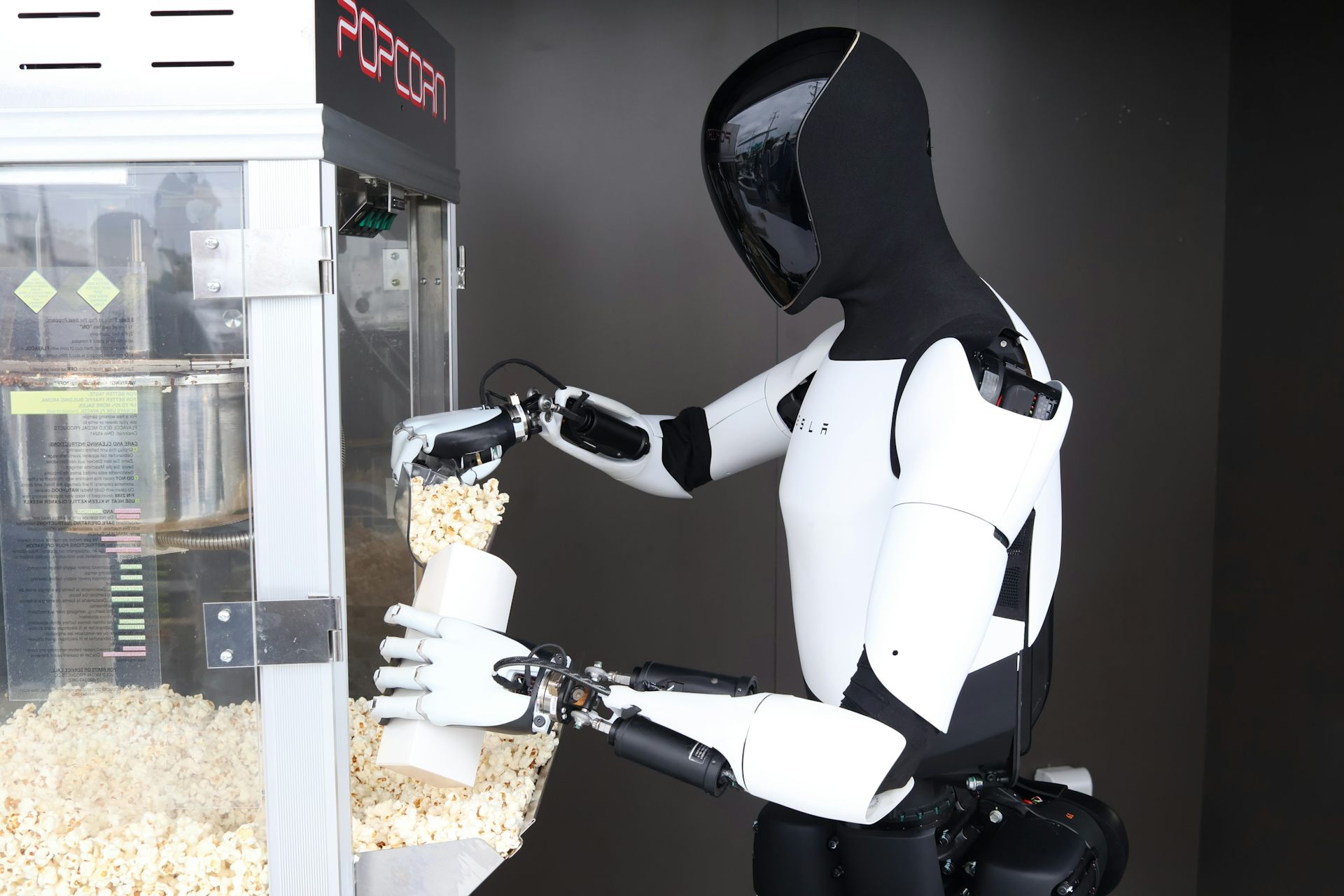 An Optimus humanoid robot serving popcorn