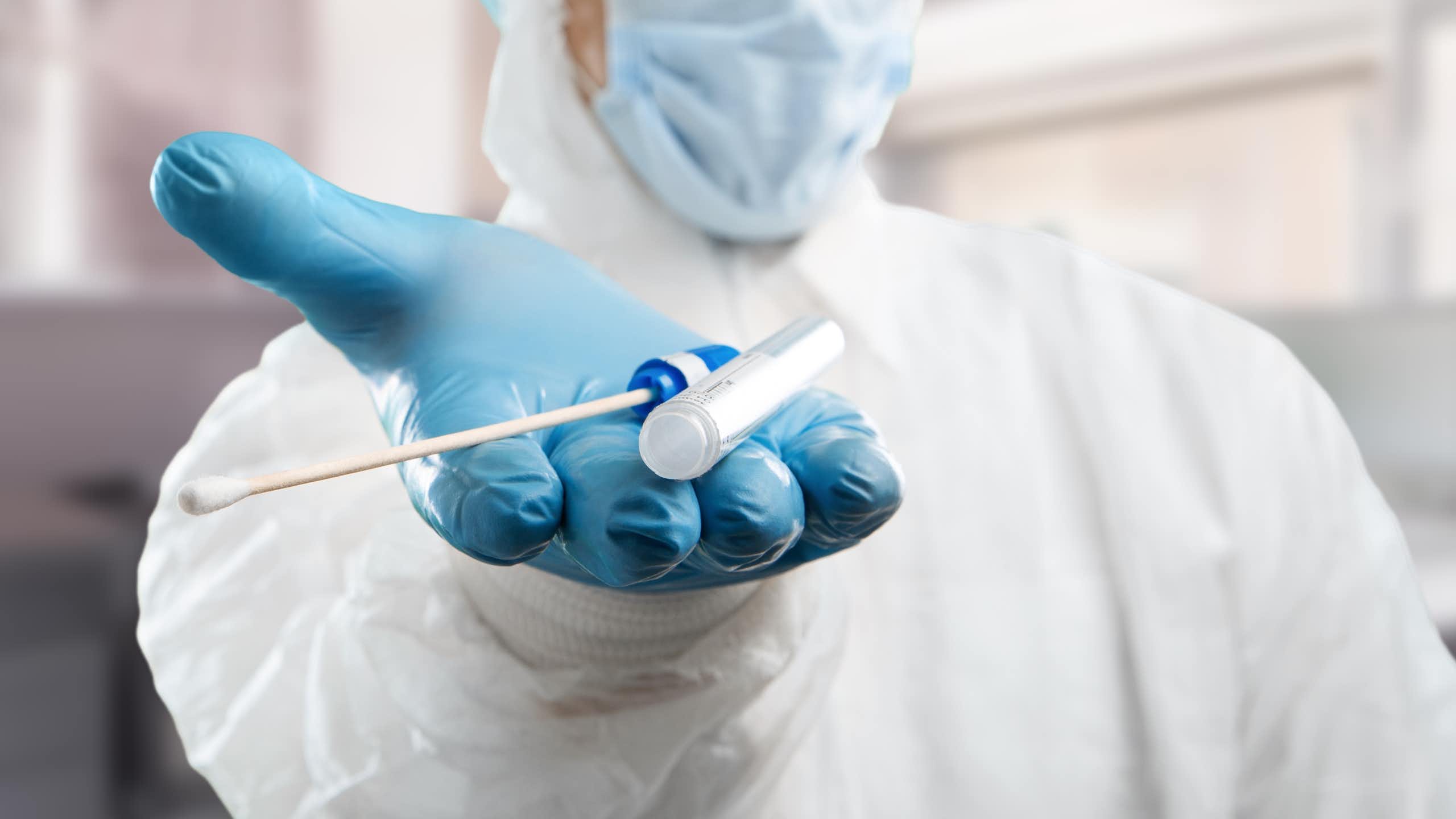 Medical lab assistant holds out donor suitability test for artificial insemination