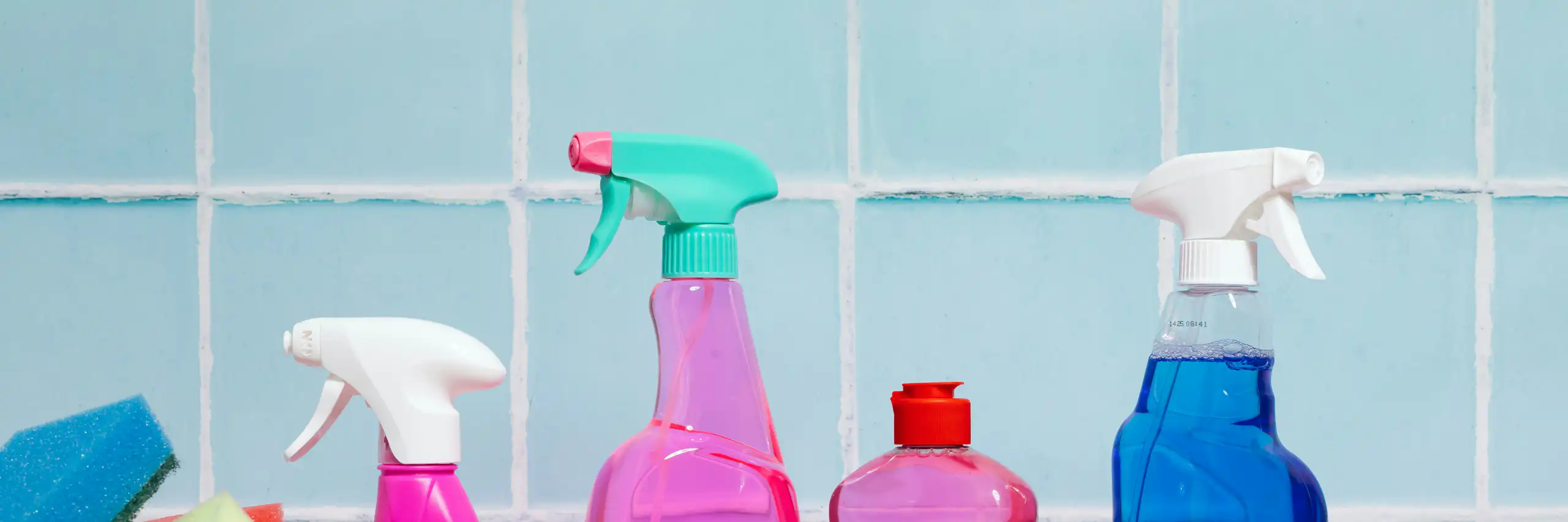Brightly coloured spray bottles and sponges