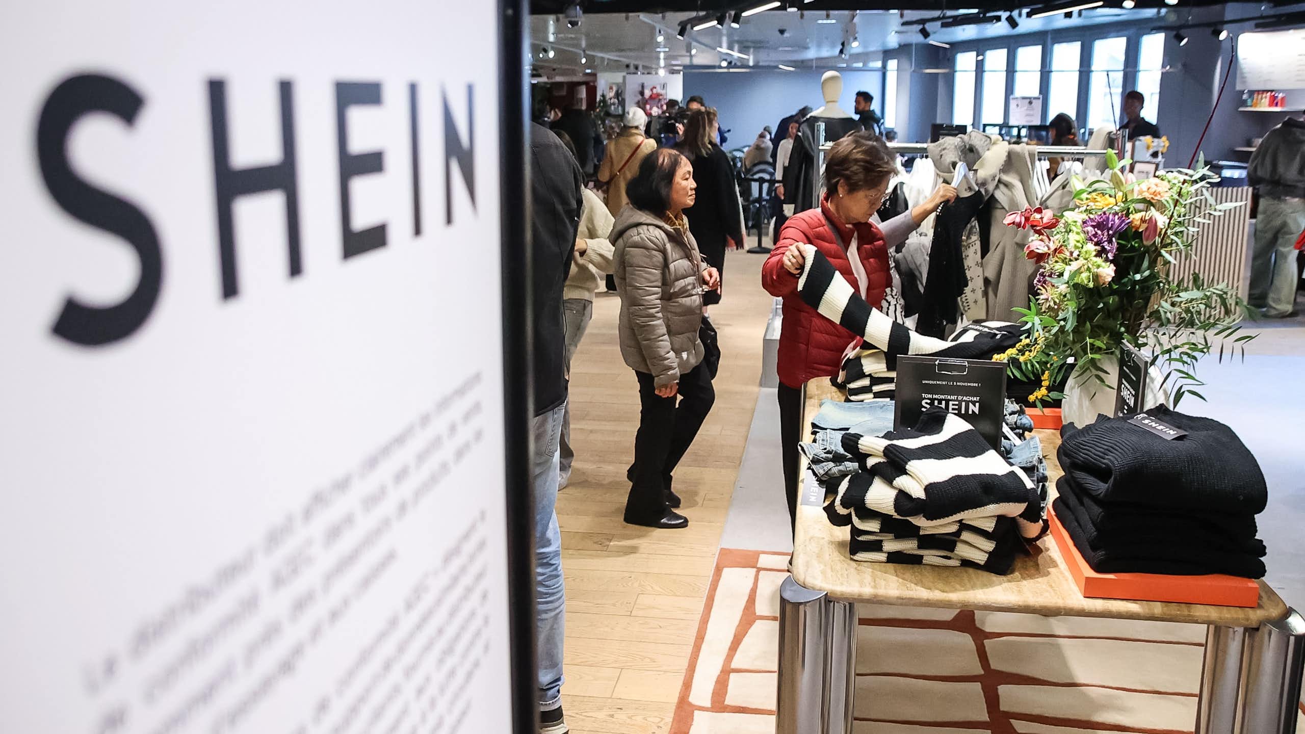 shoppers browse the clothes at the first shein store in paris.