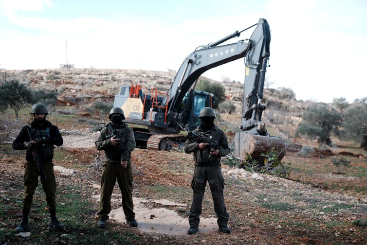 West Financial institution violence is hovering, fueled by means of a capitulation of Israeli establishments to settlers’ pursuits 2 Three soldiers stand in front of a mechanical digger
