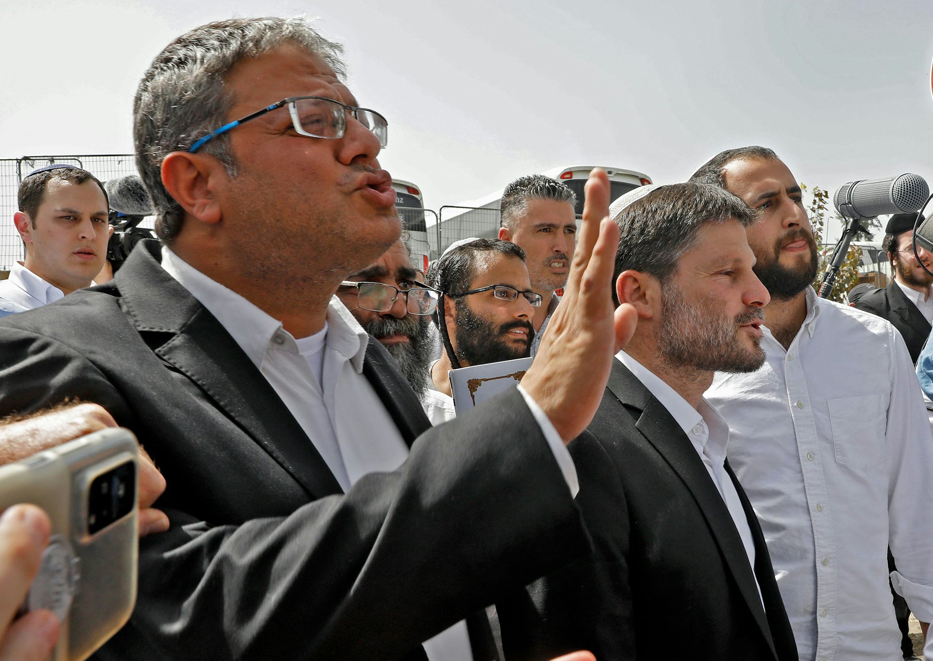 Men in suits gesticulate with their hands.