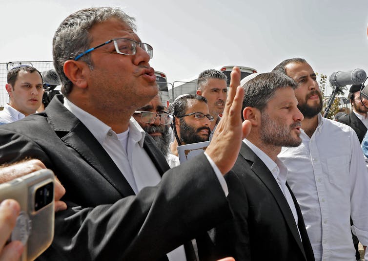 West Financial institution violence is hovering, fueled by means of a capitulation of Israeli establishments to settlers’ pursuits 1 Men in suits gesticulate with their hands.