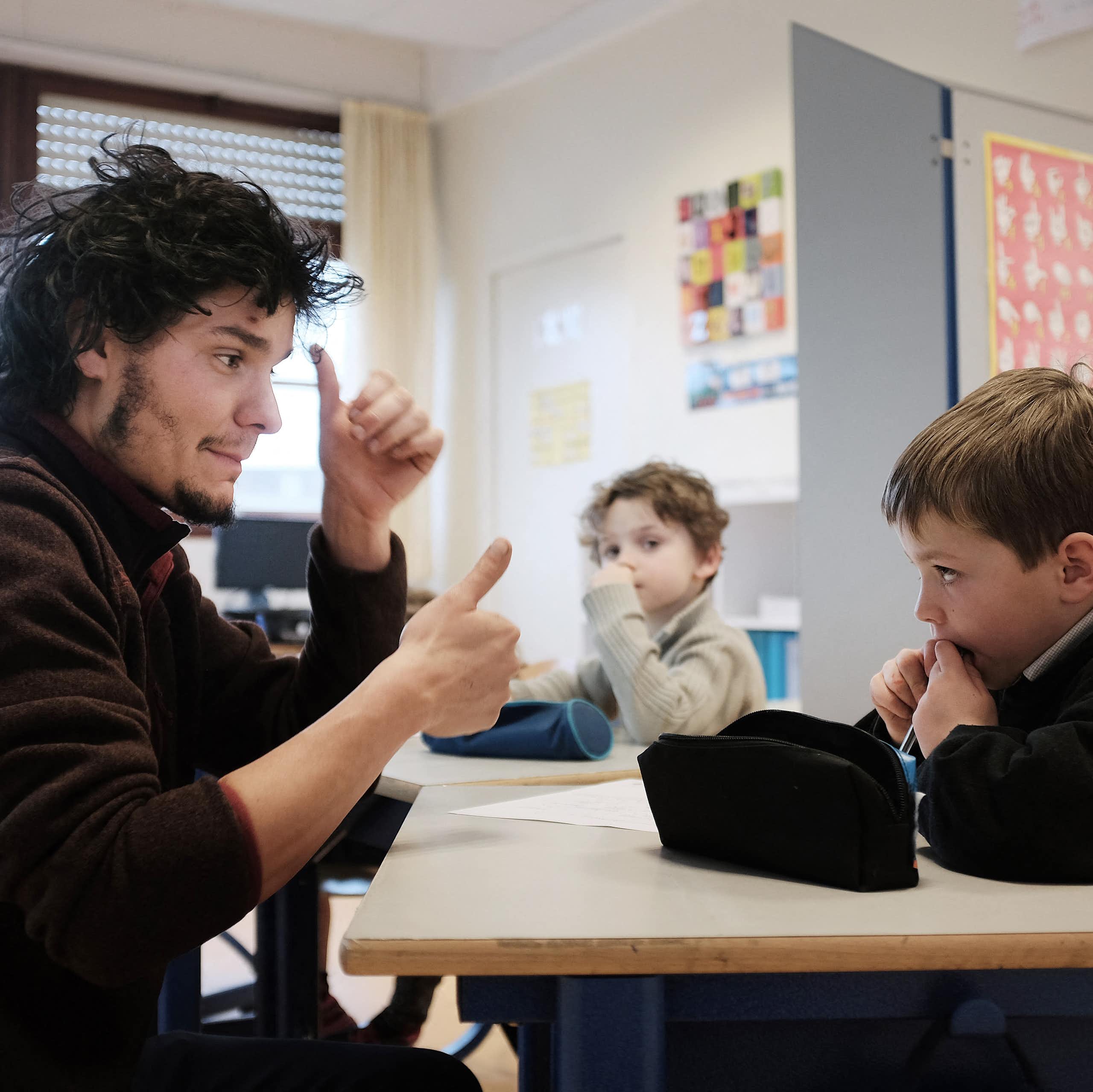 Un professeur des écoles enseigne la langue des signes à des élèves malentendants dans un établissement de Rennes, en 2015.