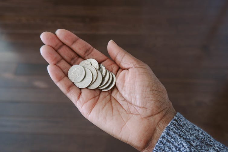 A woman's hand holding coins.