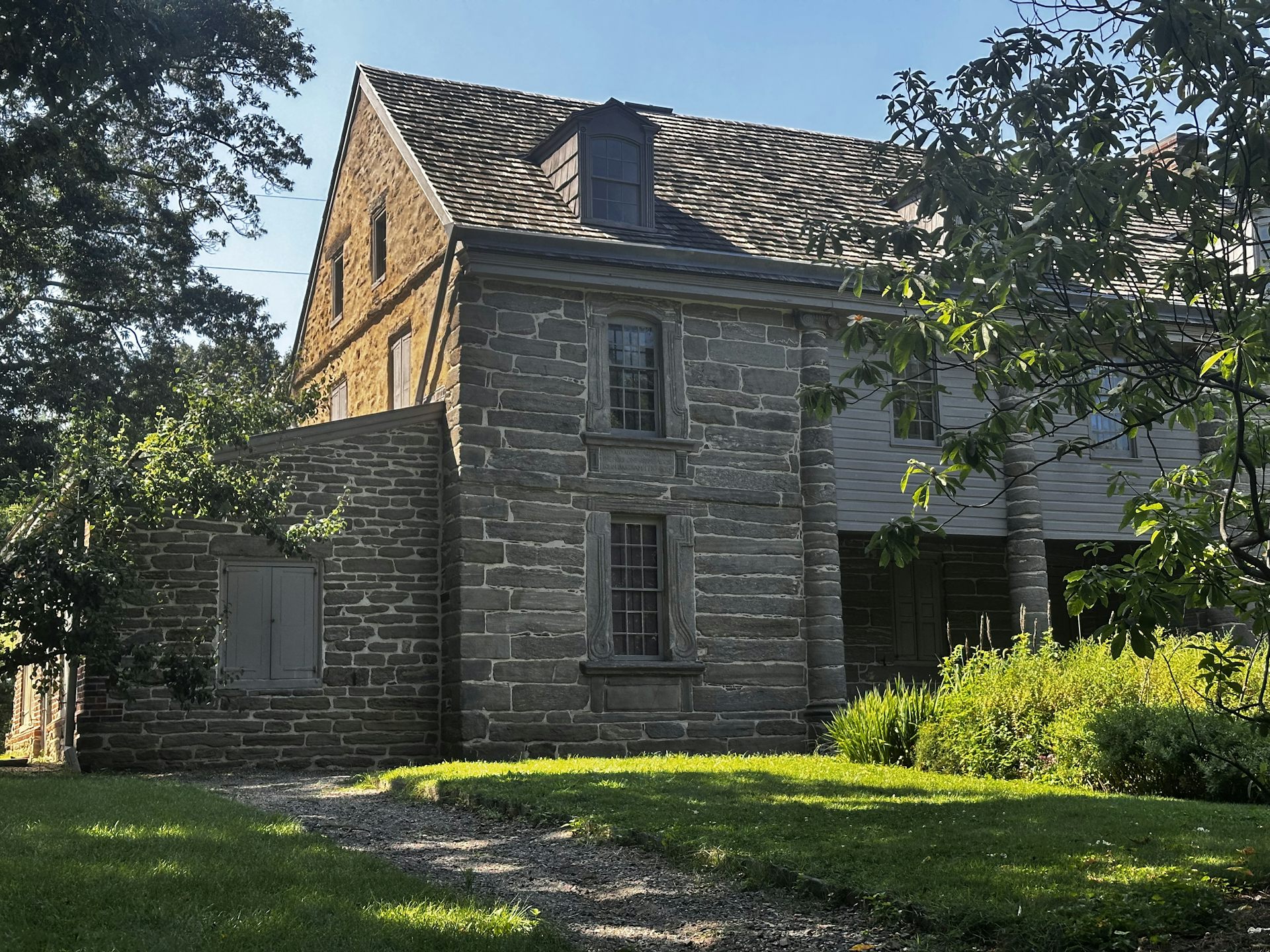 Exterior view of old stone building surrounded by grass and trees