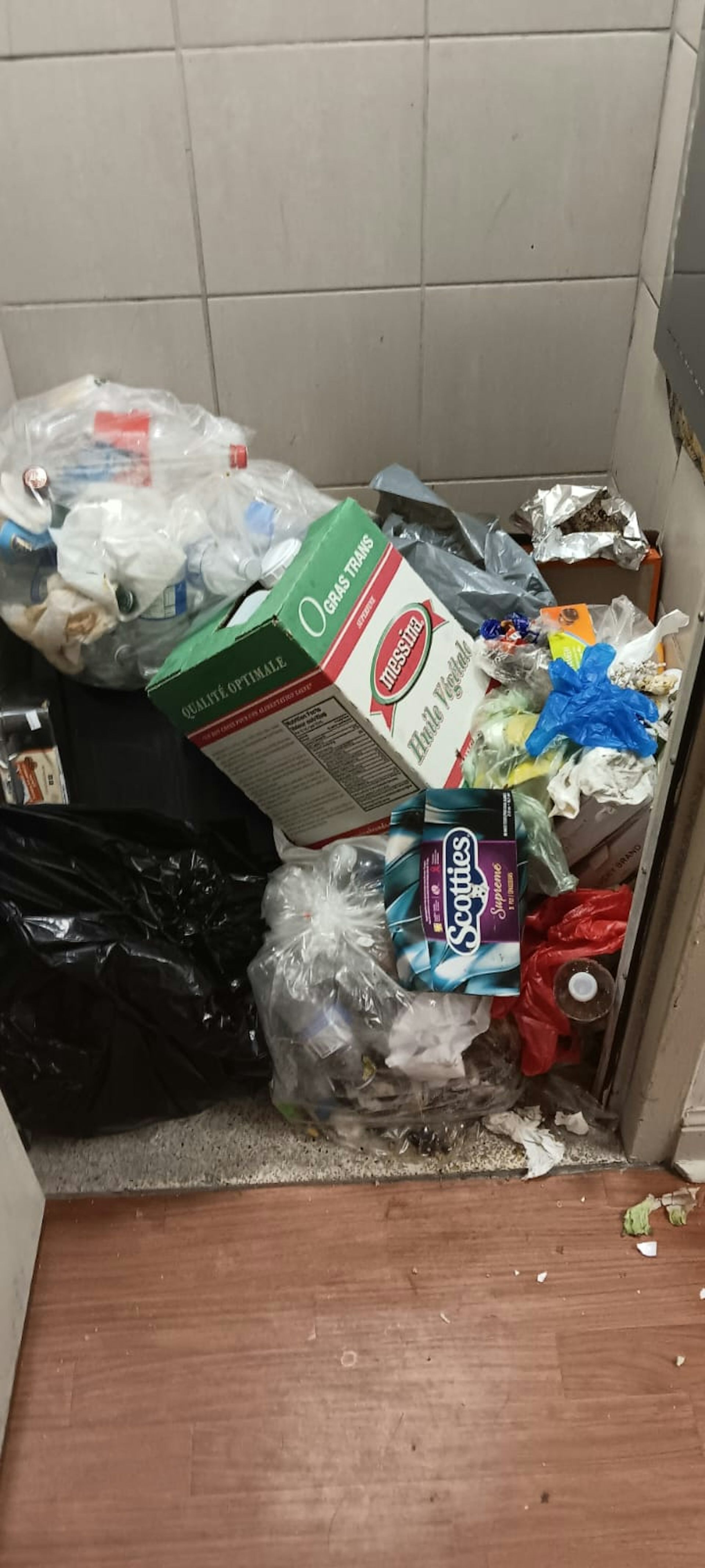 a pile of trash near a garbage chute.
