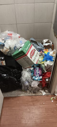 a pile of trash near a garbage chute.